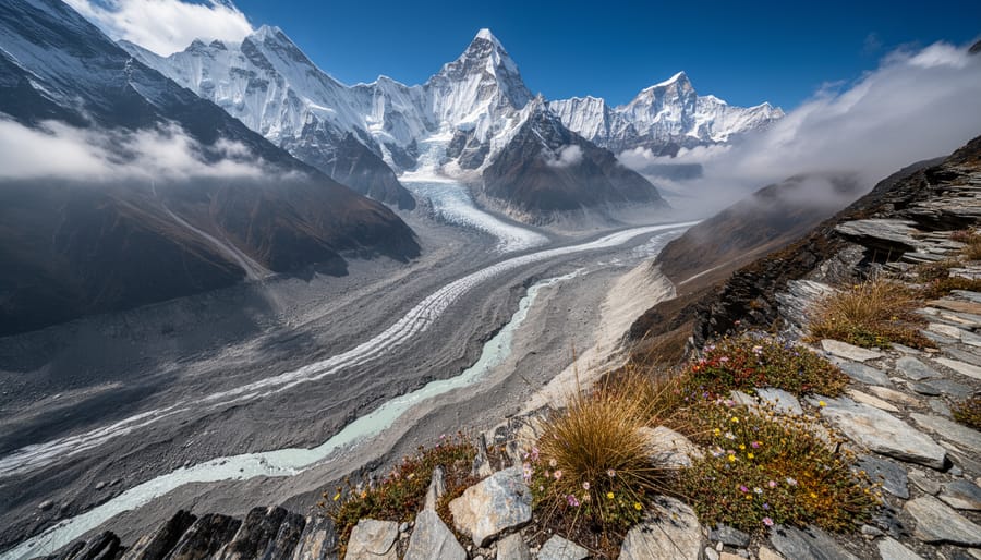 Wide view of a Himalayan valley with a snow and ice-covered slope above a river under dramatic cloudy light